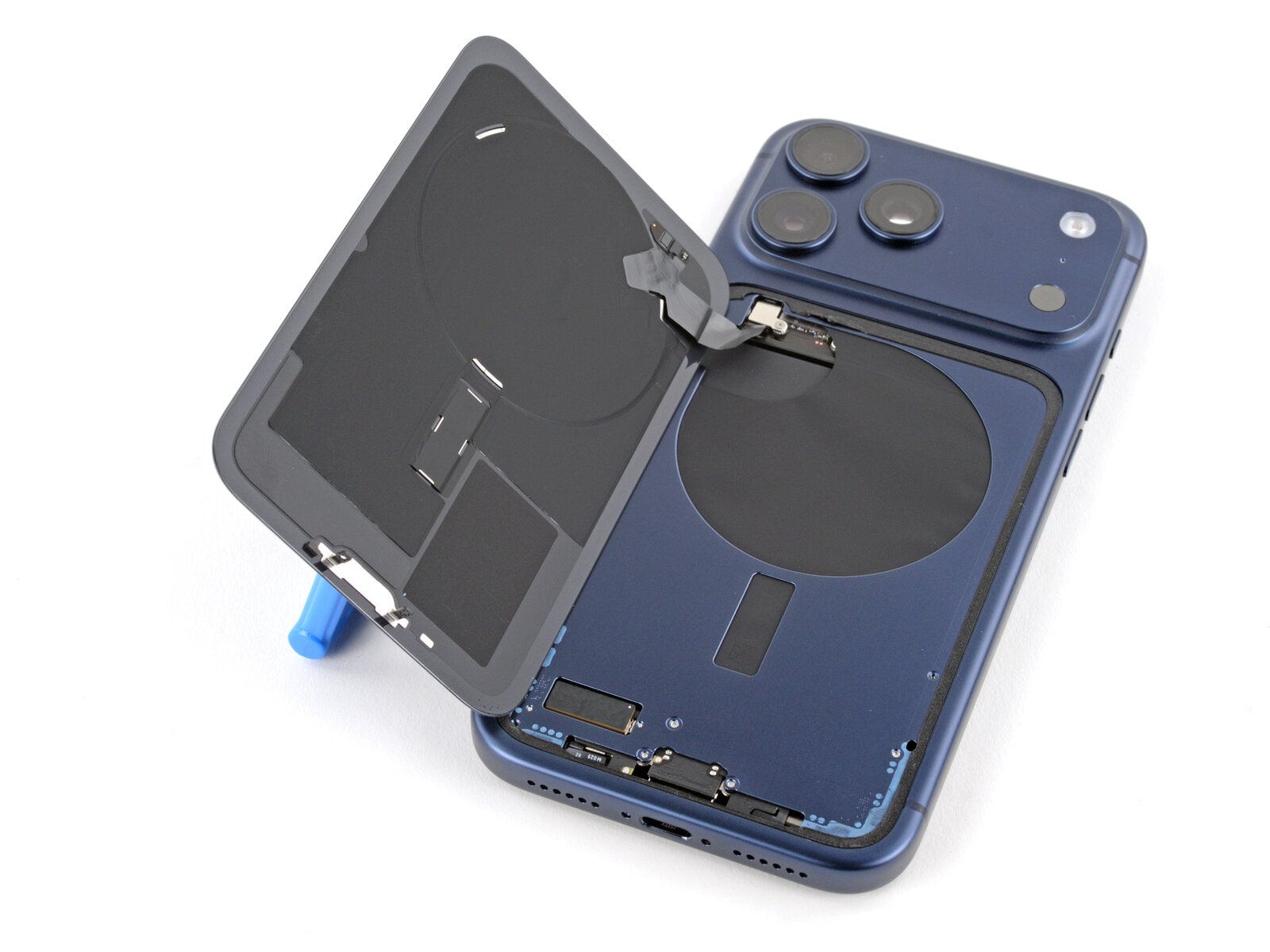 iPhone Pro azul abierto en reparación, con la tapa trasera y el módulo MagSafe levantados — iService express Boulogne San Isidro